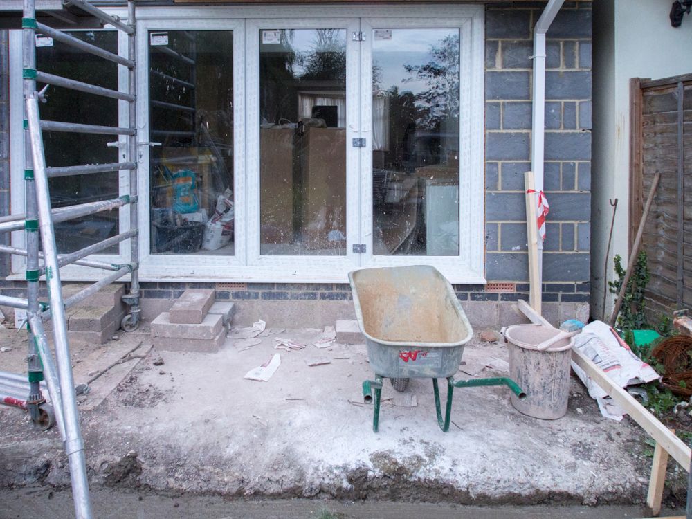 Licensed stock photograph of a renovation site with scaffolding and a wheelbarrow
